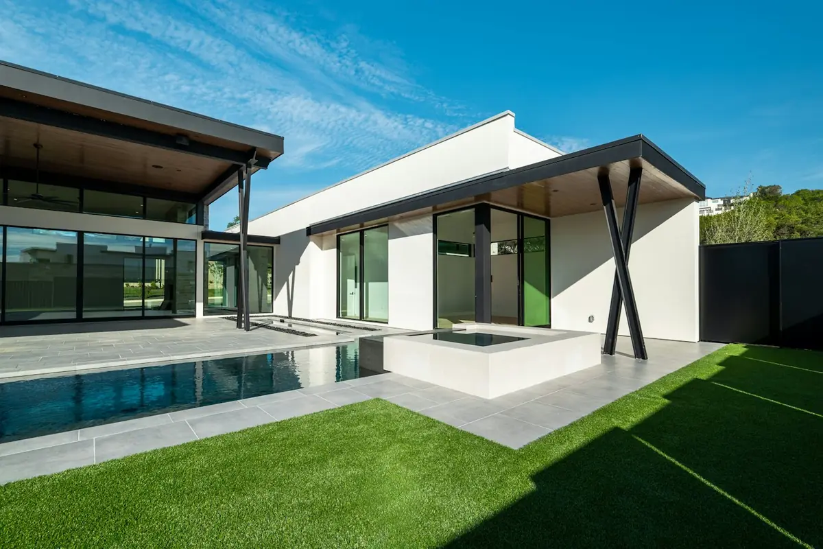 Modern backyard with a level green lawn beside a pool